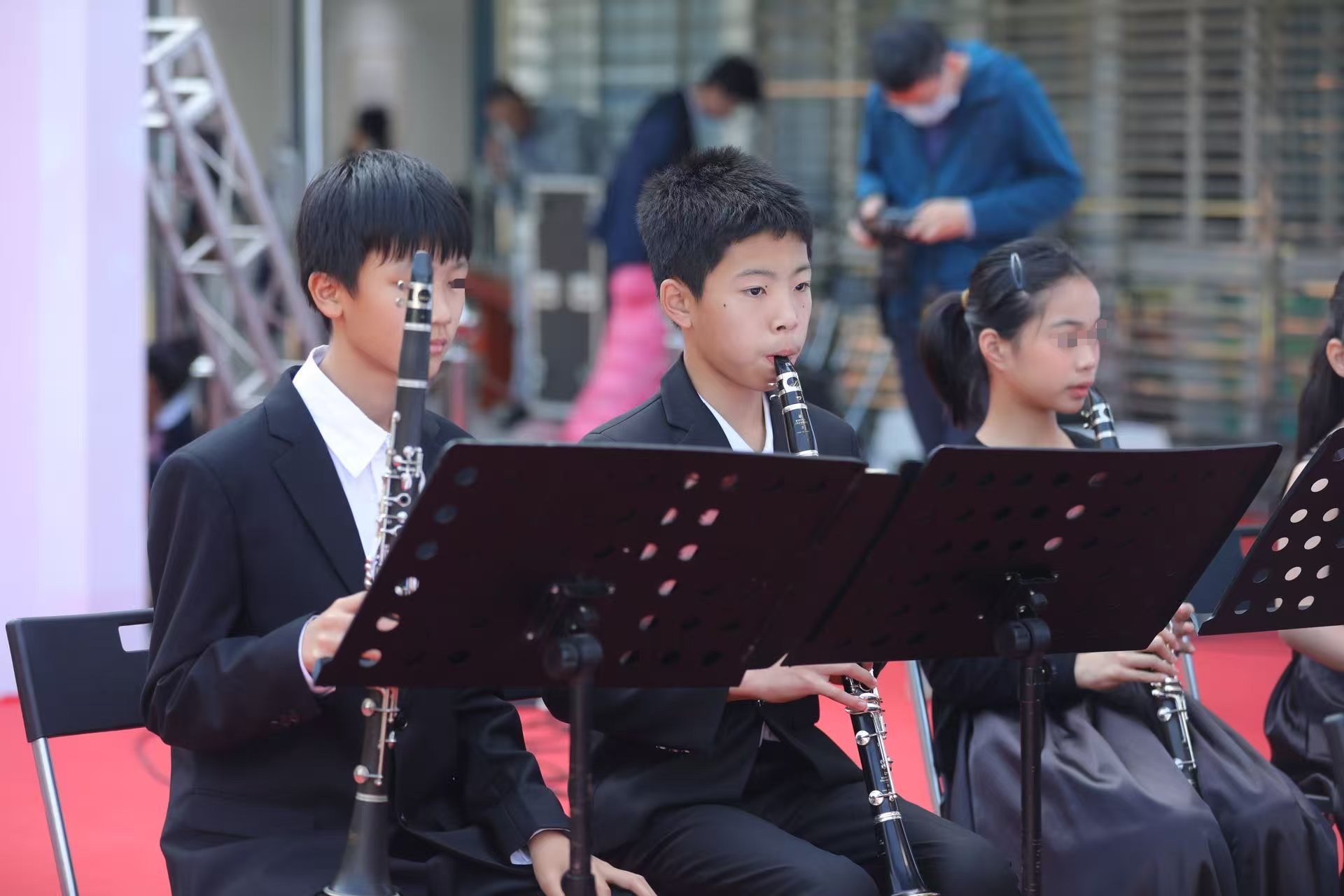 Playing clarinet with the school concert band, other students' faces blurred