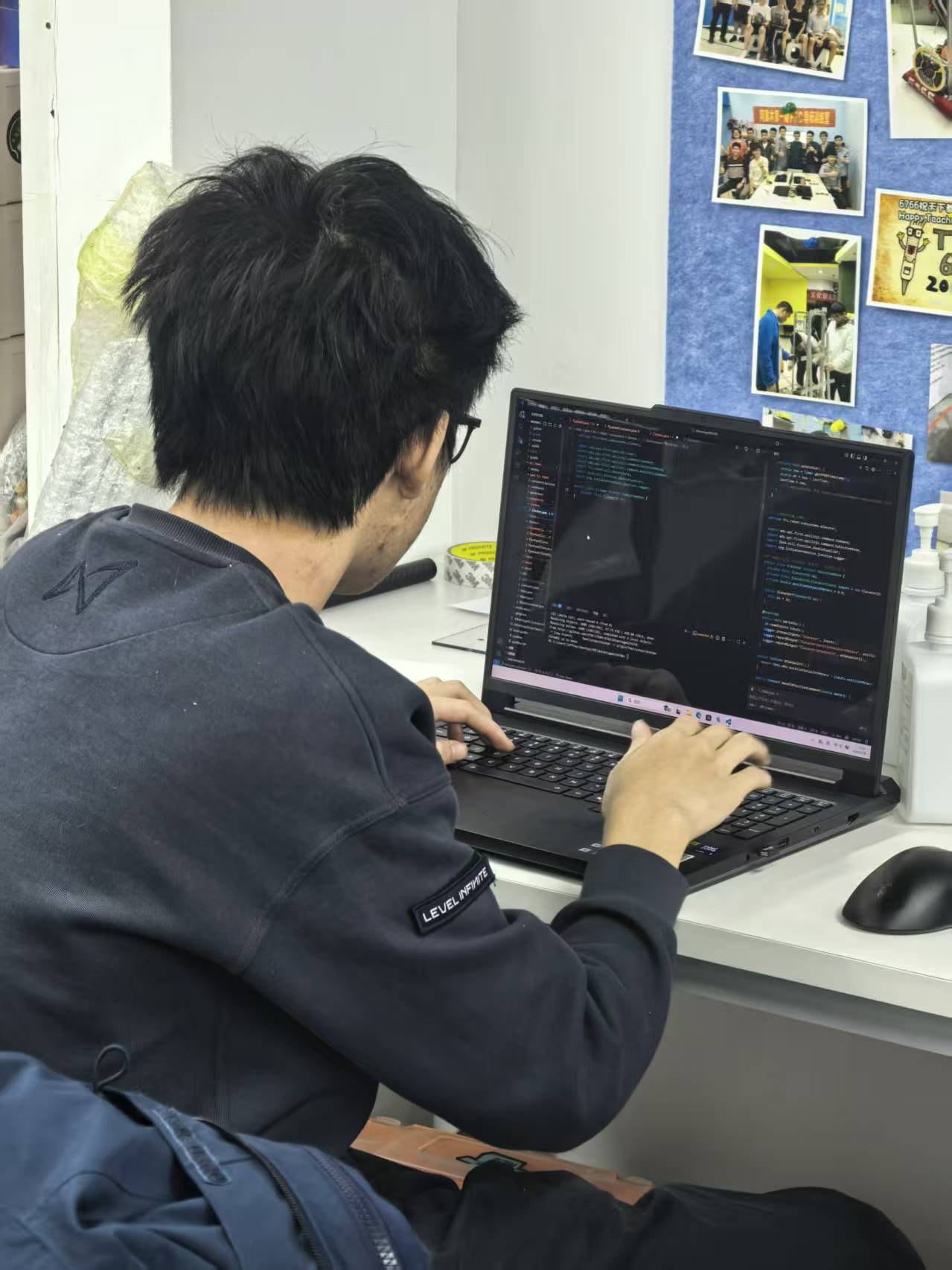 Writing robot code at a team training session, seen from behind